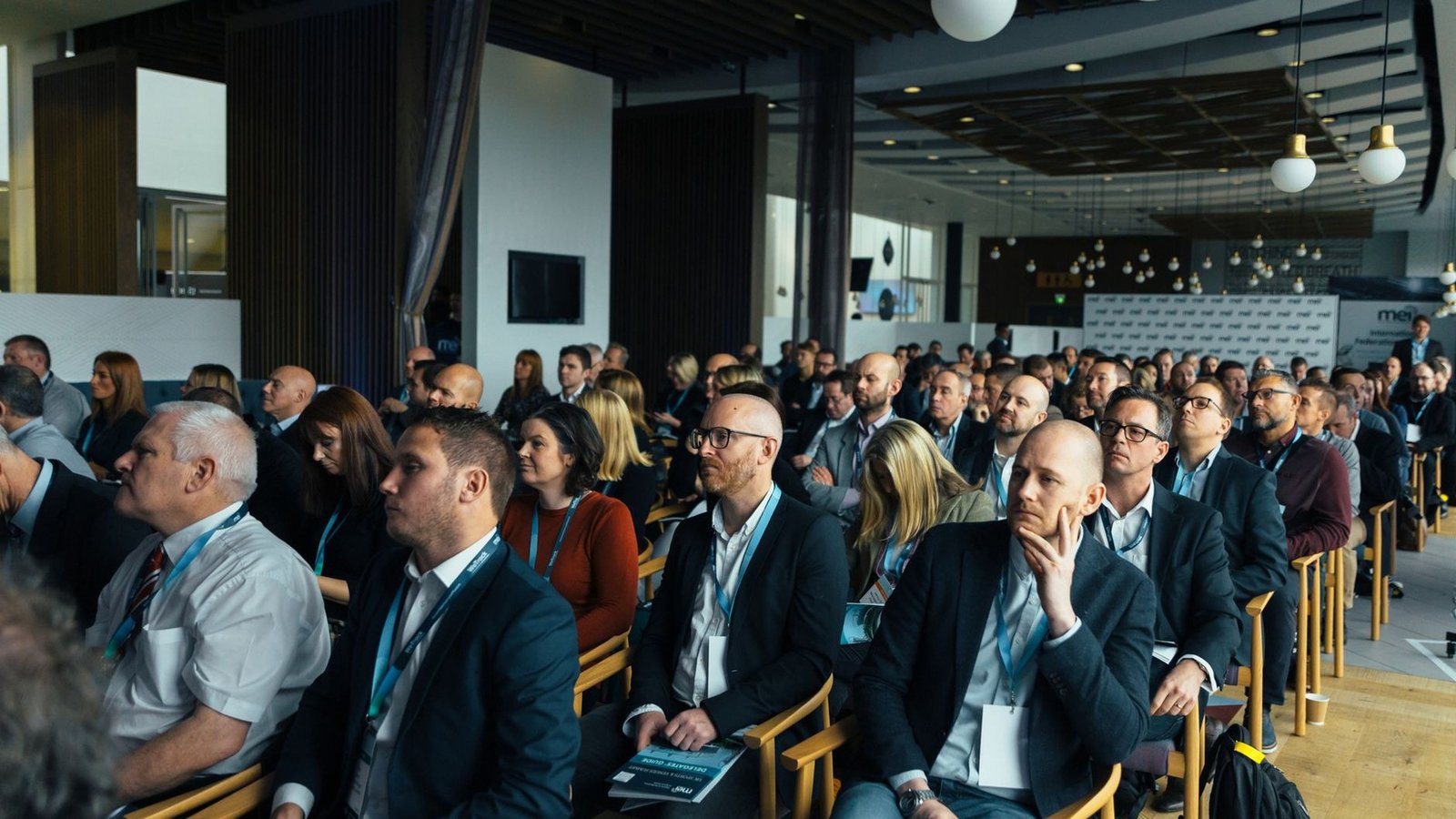 Plateia acompanhando apresentação em auditório de evento corporativo