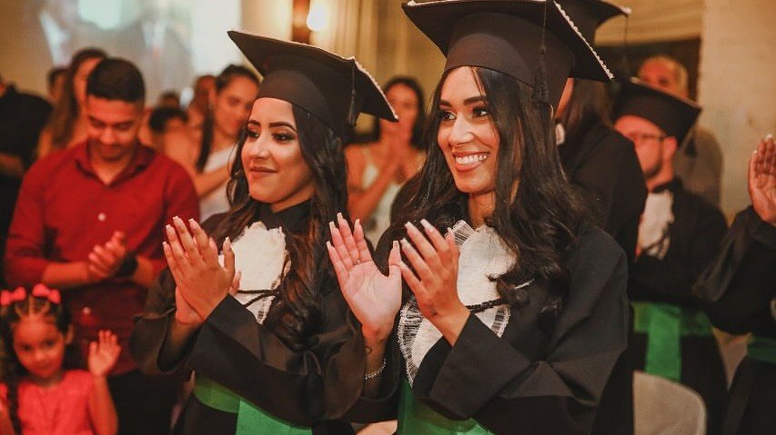Formandas aplaudindo emocionadas durante a cerimônia de colação de grau